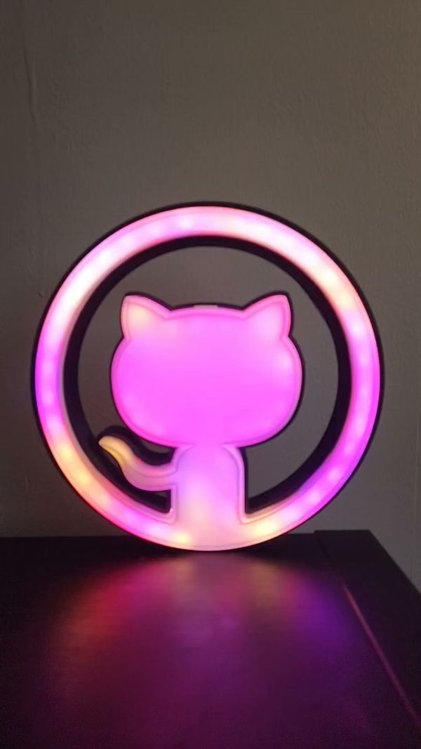 Photo of Github Logo Lamp lit up in shades of pink