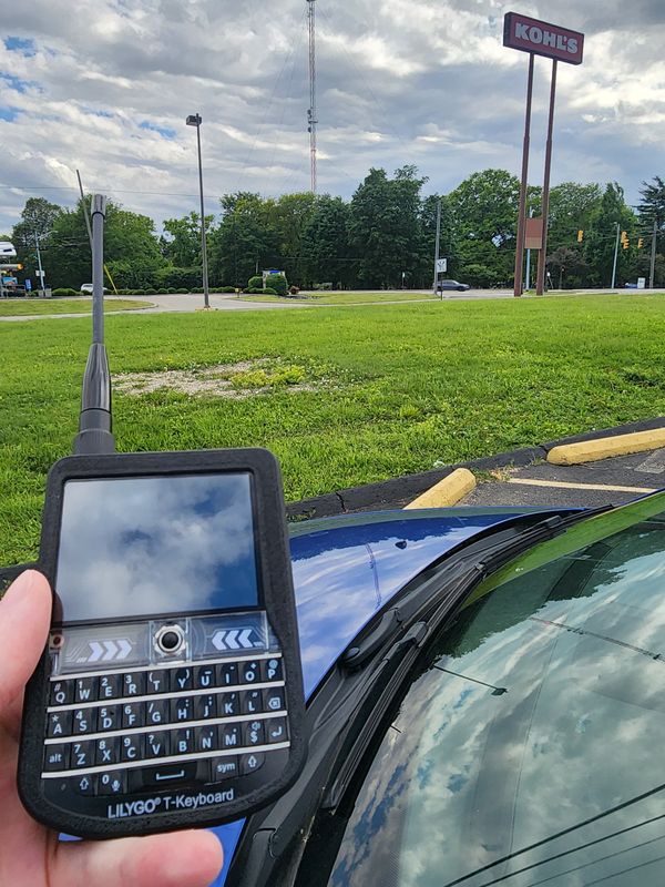 Photo of the LILYGO TDeck with a Kohl's Sign in the background
